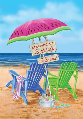 Beach scene with colorful chairs, watermelon umbrella, and 'Reserved for 5 o'clock or Sooner!' sign.