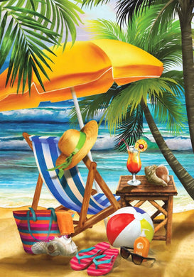 Beach scene with lounge chair, umbrella, and beach accessories.